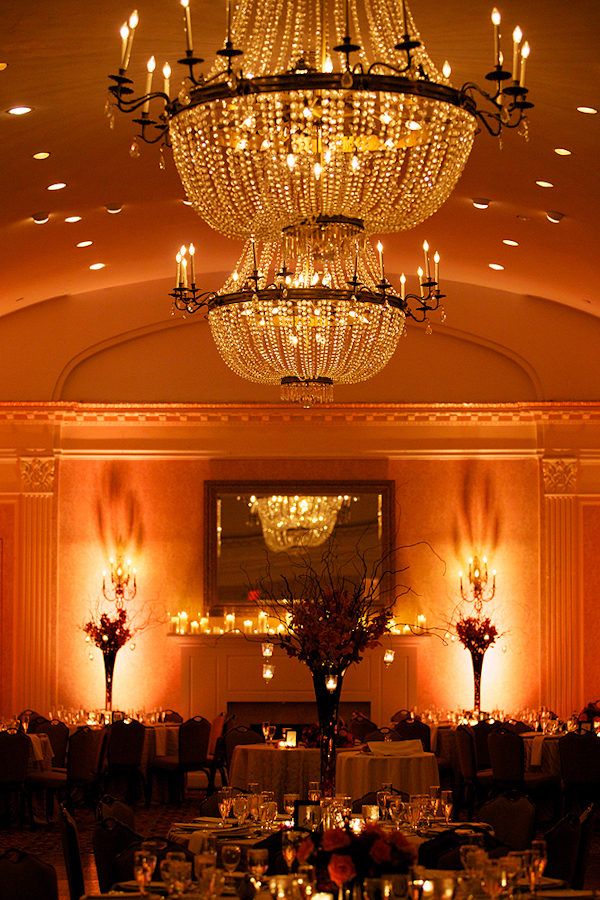 chandelier hangs over orange and red table settings - wedding photo by top Philadelphia based wedding photographers Langdon Photography